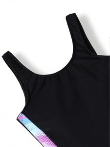Detail of girls' black one-piece swimsuit featuring colorful geometric stripe prints