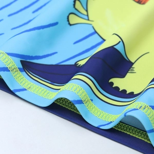 Detail of quick-dry swim fabric with dinosaur print and yellow stitching