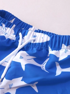 Dettaglio dei pantaloncini da bagno blu per bambini con squali bianchi e vita elasticizzata