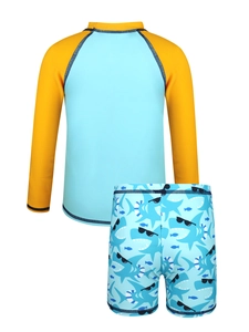 Detail of boys' two-piece swimsuit featuring blue shark print and yellow raglan sleeves