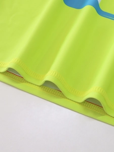Close-up of quick-dry fluorescent green swimwear fabric with reinforced double-stitch hem