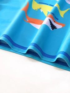 Dettaglio di stampe a squalo e orlo a doppia cucitura su costume blu bimbo