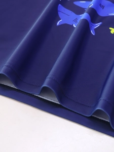 Dettaglio della stampa squalo blu e cuciture piatte su tessuto costume da bagno bimbo