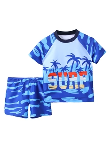 Flat lay of boys' two-piece swimsuit with SURF print and blue camo shorts