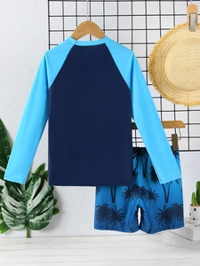 Detail of boys' long-sleeve two-piece swimwear set with palm tree prints on shorts