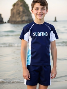 Close-up of boys short-sleeve rash guard and shorts with surfing print on beach