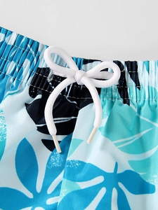 Macro detail of elastic waistband and white drawstring on tropical print boys swim trunks