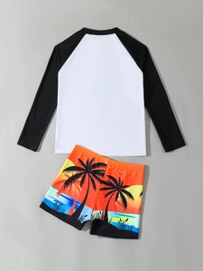 Detailed flat lay of boys' rash guard set with black-and-white sleeves and palm tree shorts