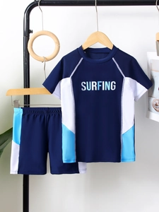 Detailed view of kids' two-piece short sleeve surfing swimwear in navy with sport patterns