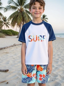 Detail of boys' two-piece swimsuit featuring SURF letter print and tropical floral beach shorts