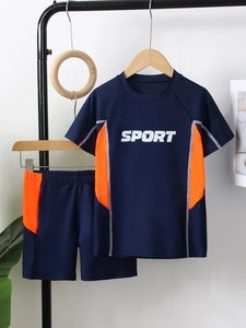 Detail of boys' two-piece short sleeve swimwear with navy blue and orange color block design