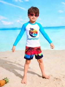Detail of boys long sleeve rash guard and swim shorts with coconut tree print