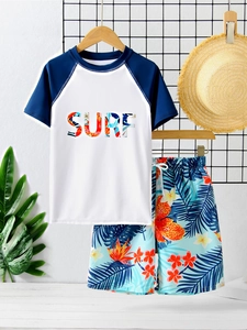 Detail of boys' two-piece swimsuit featuring SURF print top and floral beach shorts