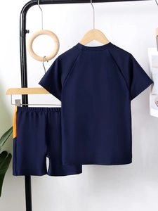 Detail of boys navy short sleeve swimwear with orange side stripes and elastic waistband