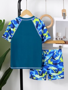 Dettaglio di un costume da bagno due pezzi per bambini con stampa mimetica squalo blu
