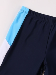 Detailed macro view of navy blue boys' swim shorts with elastic waist and side panels