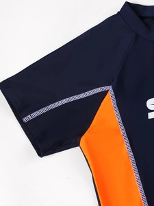 Detail of flatlock stitching and orange side panels on boys navy athletic swimwear