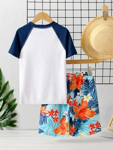 Detail of boys' two-piece swimsuit with raglan sleeves and tropical print shorts