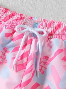 Close-up of pink floral print swimwear shorts with elastic waist and white drawstring bow