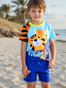 Detail van tweedelig jongenszwempak met cartoon tijgerprint en raglanmouwen op strand