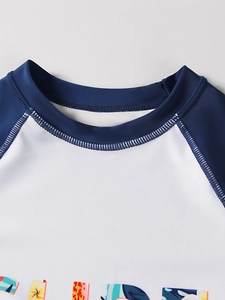 Detail of boys' rash guard with raglan sleeves, fine stitching and letter print