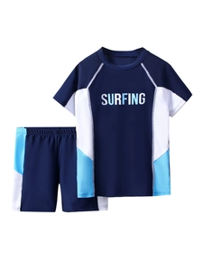 Detail of two-piece boys swimwear set featuring SURFING print and blue panels