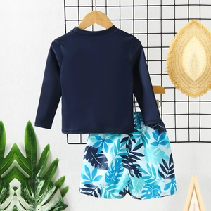 Two-piece boys' long sleeve swimwear with blue rash guard and tropical floral swim shorts