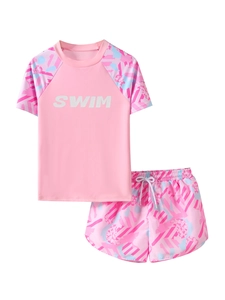 Close-up of pink two-piece girls' swimwear with SWIM print and geometric pattern detail