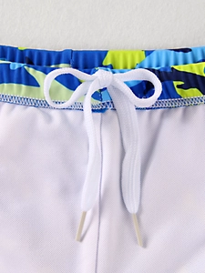 Dettaglio dei pantaloncini da bagno bimbo con vita mimetica blu e cordoncino bianco