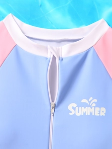 Detail of girls long sleeve swimsuit featuring zipper guard and SUMMER graphic print