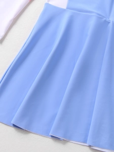 Detailed view of kids' swimsuit fabric showing light blue skirt hem and smooth texture