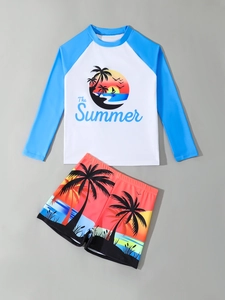 Detail of two-piece boys swimwear featuring long sleeves and coconut tree sunset print