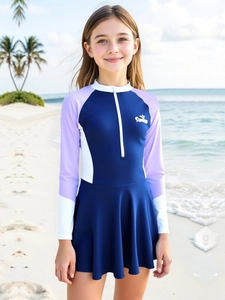 Detail of girls long sleeve swimsuit with Summer print and half-zip neck on sunny beach