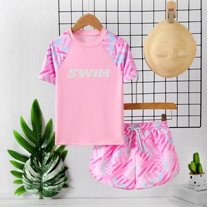 Pink two-piece girls swimset with short sleeves and geometric print shorts