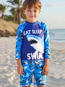 Outdoor beach scene showing long sleeve shark print kids swimsuit with sun protection