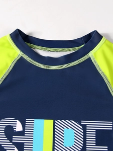 Detail of boys rash guard neck stitching and surf print in navy and yellow