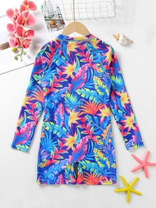 Detail of children's long-sleeve swimsuit with tropical floral print and beach accessories