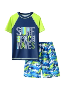 Detail of boys' two-piece swimwear with shark print pants and navy rash guard top