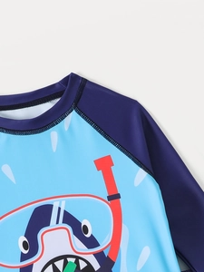 Détail du haut de bain requin pour garçon avec coutures, motif cartoon et manches raglan