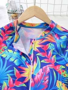 Detail of girls' long sleeve swimsuit featuring tropical floral prints and chest zipper