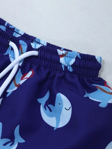Détail du short de bain bleu pour garçons avec motif requin et taille à cordon blanc