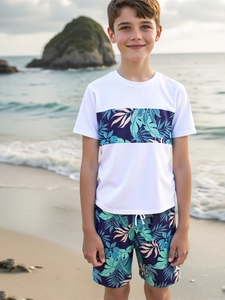 Boy's two-piece swimsuit set with tropical palm leaf print on a scenic beach background