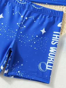 Vue macro du tissu de maillot de bain bleu marine pour garçon avec motifs de planètes