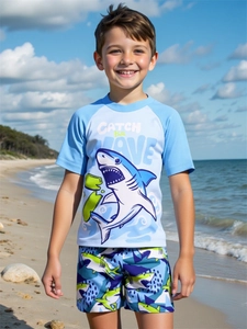 Detail van tweedelige kinderzwemkleding met haaienprint op een zonnig strand