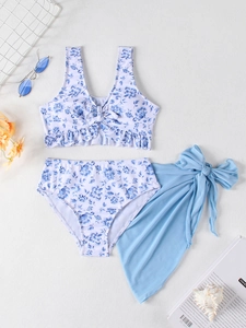 Flat lay of girl's blue floral three-piece bikini set with ruffles and a mesh sarong