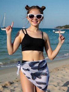 Detail of girls one-shoulder bikini top with tropical palm leaf print sarong skirt