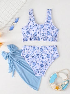 Three-piece floral bikini set with blue mesh sarong and ruffled top on beach decor