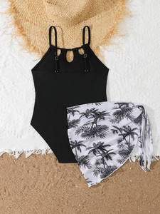 Flachbild-Kinder-Badeanzug in Schwarz mit Palmen-Sarong auf Sand im Strand-Stil