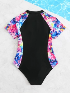 Flat lay of girl's short sleeve swimsuit with colorful gradient prints and black center panel