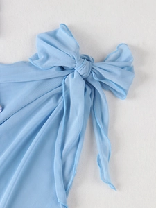 Detail shot of light blue mesh fabric with a tied knot and fine stitching on children swimwear